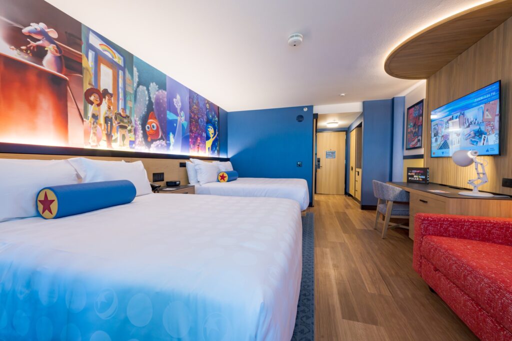 Unveiling the Magic: Pixar Place Hotel with guest rooms designed with Pixar characters on the walls and accent pieces.