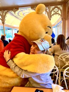 An adult hugging Winnie the Pooh