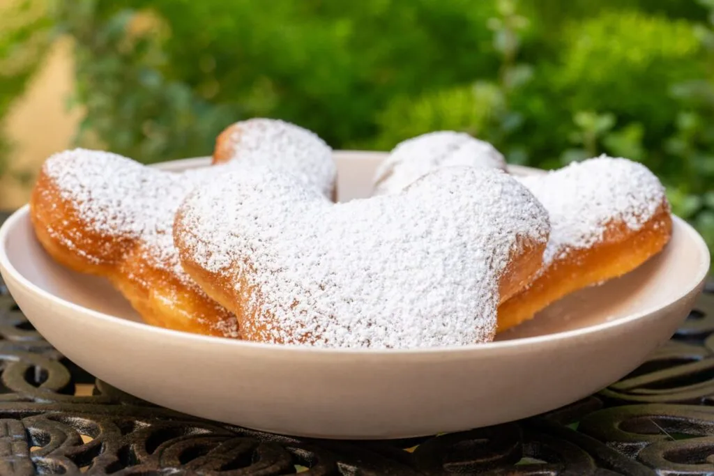 Three Mickey-shaped beignets covered with powered sugar