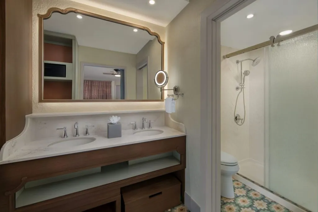 Double sink wash room. In the mirror is a reflection of open storage cabinets